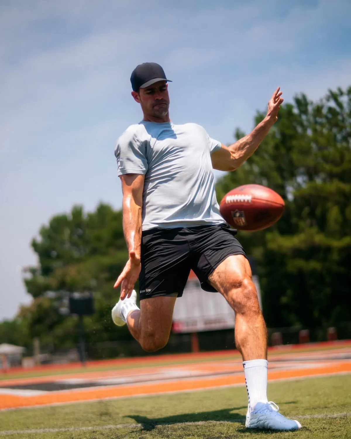 Pat O'Donnell, NFL punter #16, mid-punt with the ball in the air